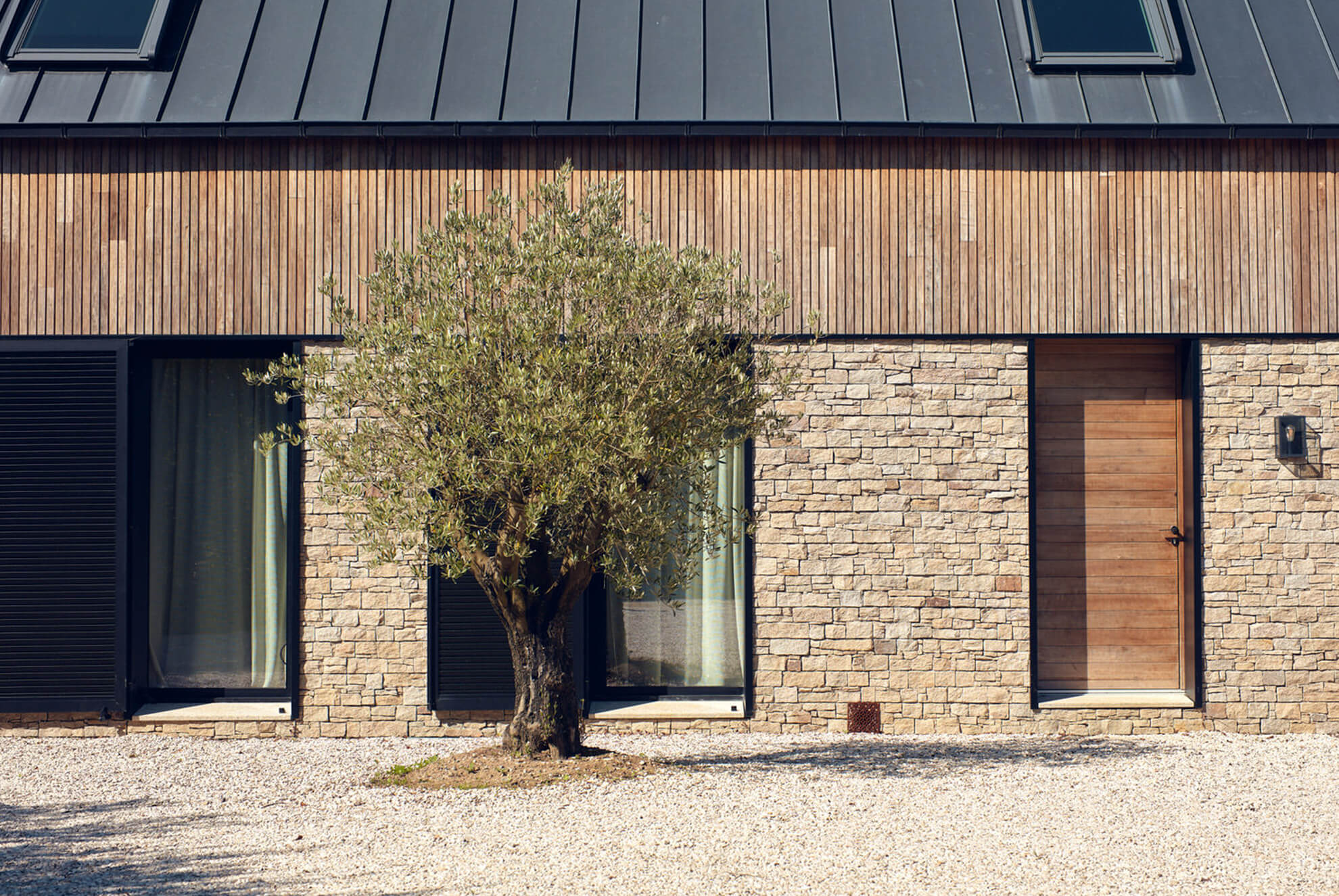 Vivienda unifamiliar de estilo tradicional, mezclando piedra natural (Stonepanel Sylvestre) con madera